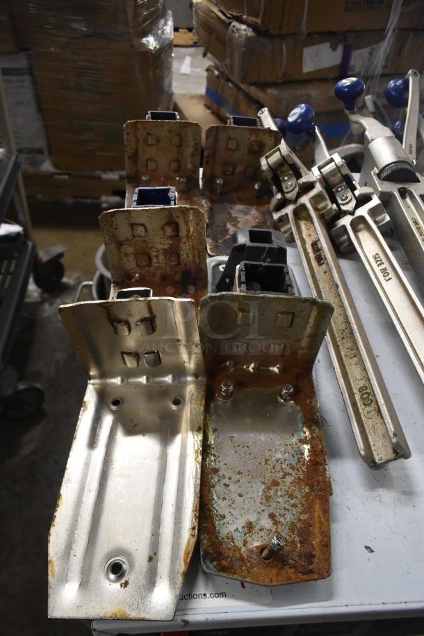 Seven commercial can openers with mounts, showing signs of rust and wear. Various models, lever handles visible.