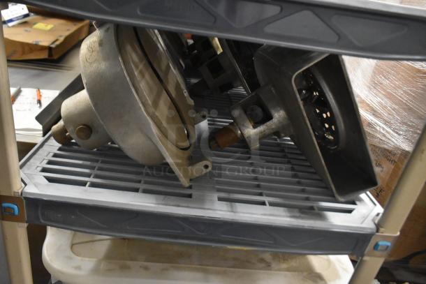 4 Pelican heads with blades for grating and slicing, no front pieces. Metal components on shelf, industrial grade.