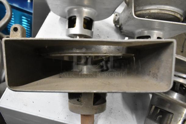 4 pelican heads with blades for grating and slicing, no front pieces, metal construction, visible wear, industrial use.