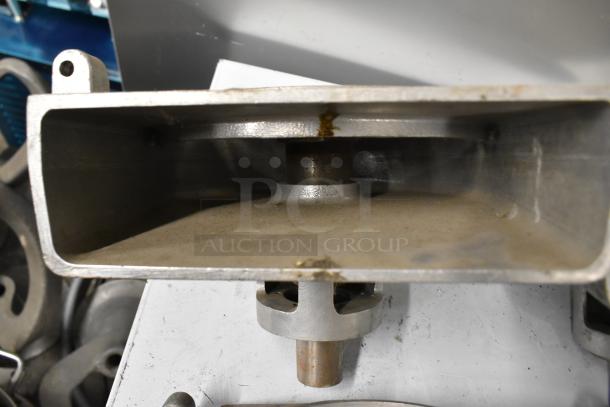 Four Pelican heads with blades for grating and slicing, no front pieces, showing metal construction and used condition.