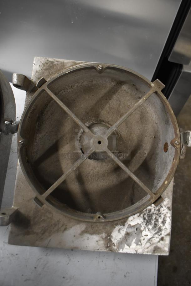 Two pelican heads with slicing blade and frame. One head missing front piece and blade. Visible wear and corrosion.