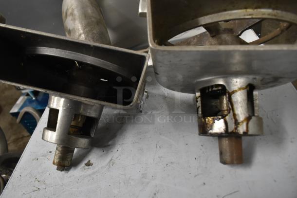 Two metal pelican heads with slicing blade and frame; one missing front piece and blade. Visible wear and rust. Auction item, bid multiplier of two.