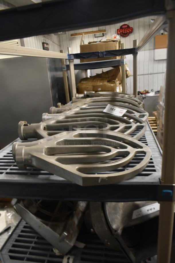 Nine paddle attachments for Hobart mixer on a shelf, metal construction, labeled with auction tag 161, in good condition.