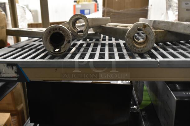 Nine metal paddle attachments for Hobart mixers on a shelf, showing signs of use. Suitable for heavy-duty mixing.