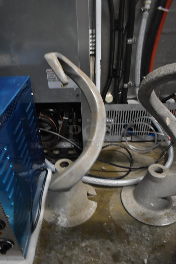 Five dough hook attachments for Hobart mixer, metal, used condition, visible wiring and equipment in the background.