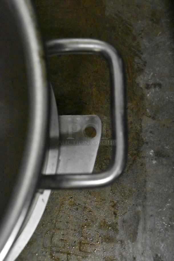 Metal mixing bowl for Hobart mixer, foreground view. Includes handle and visible industrial kitchen setting.