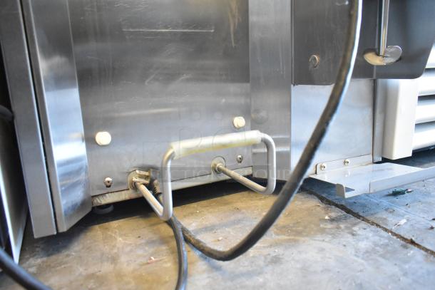 Stoelting stainless steel commercial soft serve ice cream machine with drink mixing attachment, showing cords and connectors.
