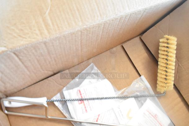 Box containing a cleaning brush with a long handle and bristles, alongside Steramine tablets in sealed packs.