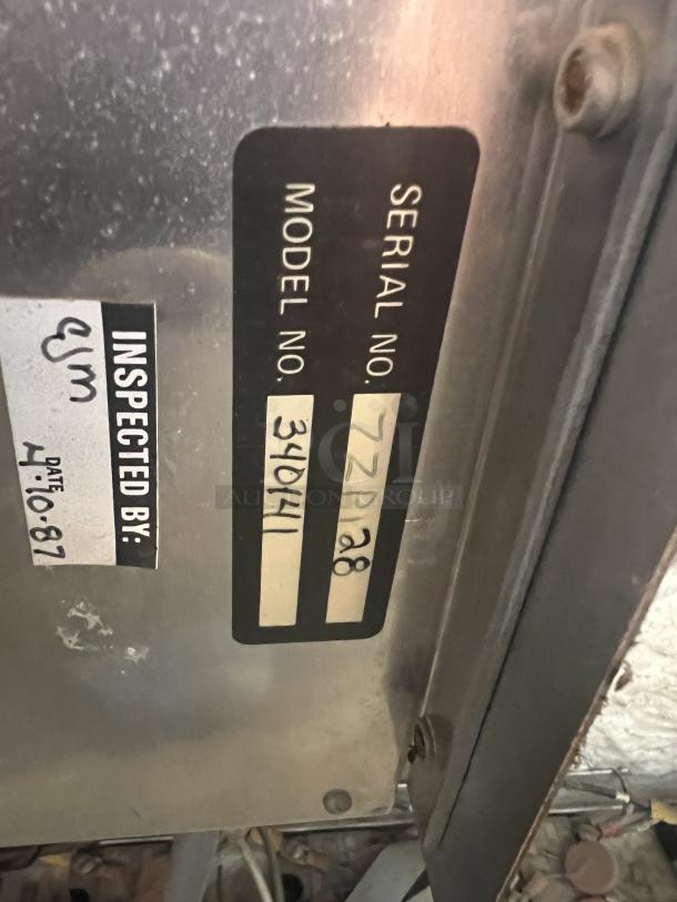 Serial and model number plate of Middleby Marshal CTX 340141 pizza oven. Tags show inspection date 4/10/87.