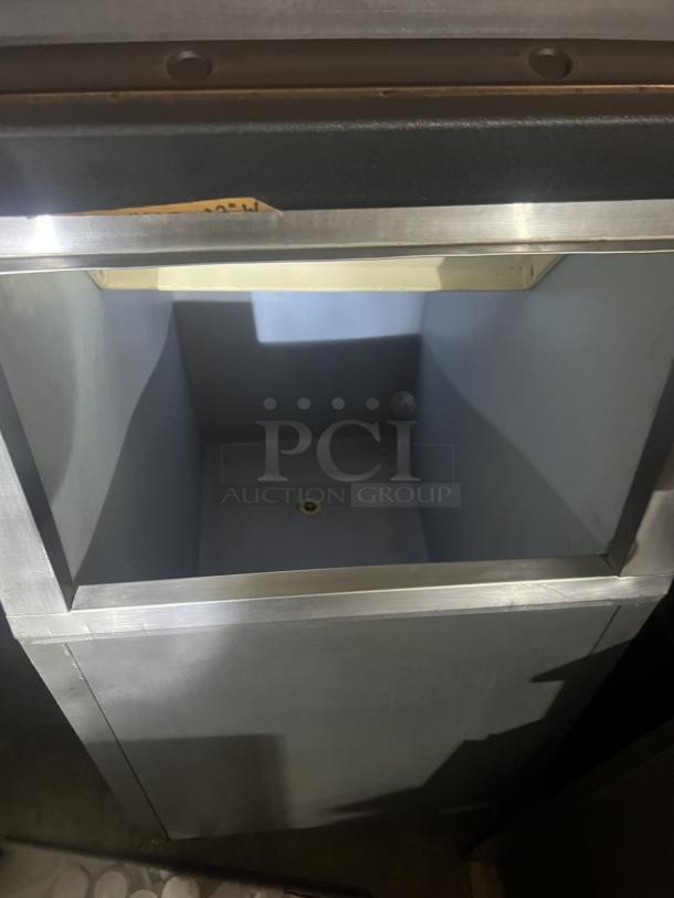 Stainless steel ice holding bin, 22x33x46 inches, featuring a wide opening and drain. Appears in good condition.