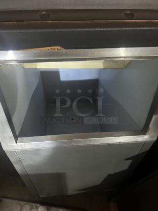 Stainless steel ice holding bin, 22x33x46 inches, featuring a wide opening and drain. Appears in good condition.