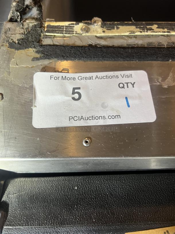 Stainless steel ice holding bin, size 22x33x46 inches. Visible wear and damage. Auction label shows quantity "5" at PCIAuctions.com.