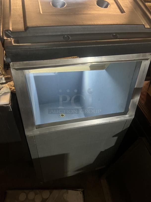 Stainless steel ice holding bin, 22x33x46 inches, with lid and drainage feature, in good condition.