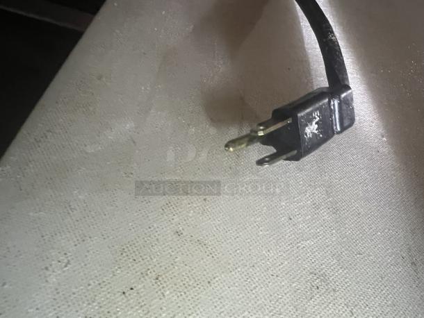 Black power plug for Berg Stainless Steel Prep Table Model EDMT-48 18 BERG, shown on textured surface.