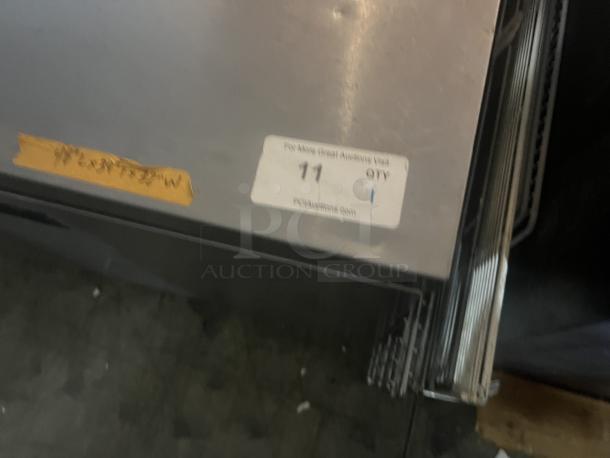 Stainless steel two-door refrigerator prep table with worktop, 48x34x32 inches, slight wear, auction tag number 11 attached.