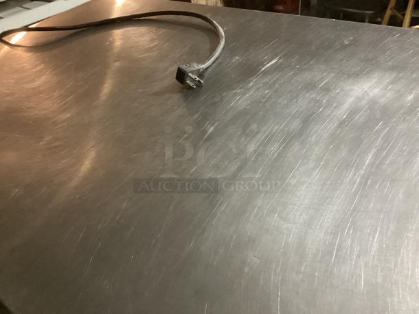 Steel surface of a Wow! refrigerated deli display case, Model TSID-48-4-L, featuring a power cord.