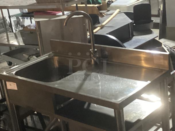 Stainless steel single sink work station, 39-½ x 20 x 35-¾ inches, with high arc faucet, slight wear, suitable for commercial use.