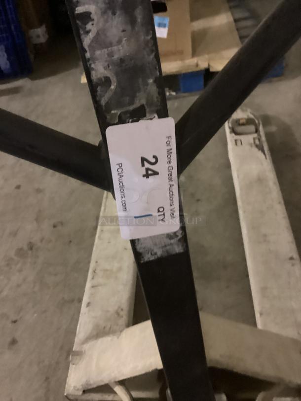 Tan pallet jack with visible wear, white tag number 24, PCI Auctions logo, suitable for heavy lifting tasks.