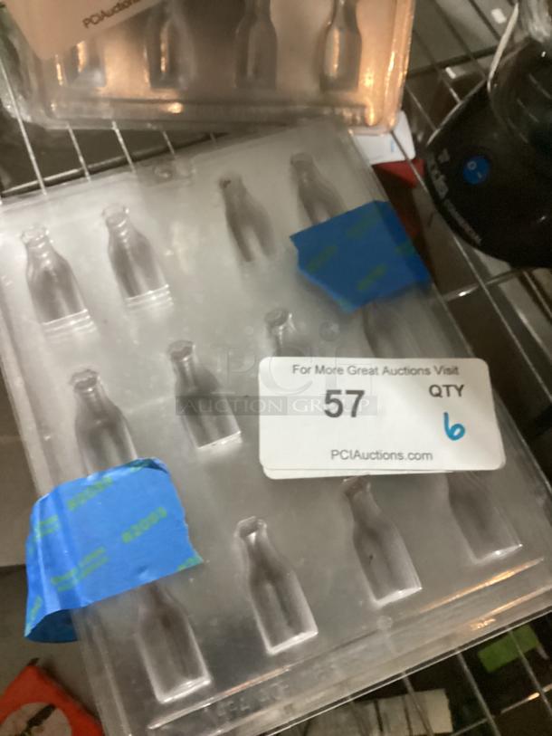 Set of six plastic wine bottle candy molds, used, each with four bottle-shaped cavities. Auction label marked "57".