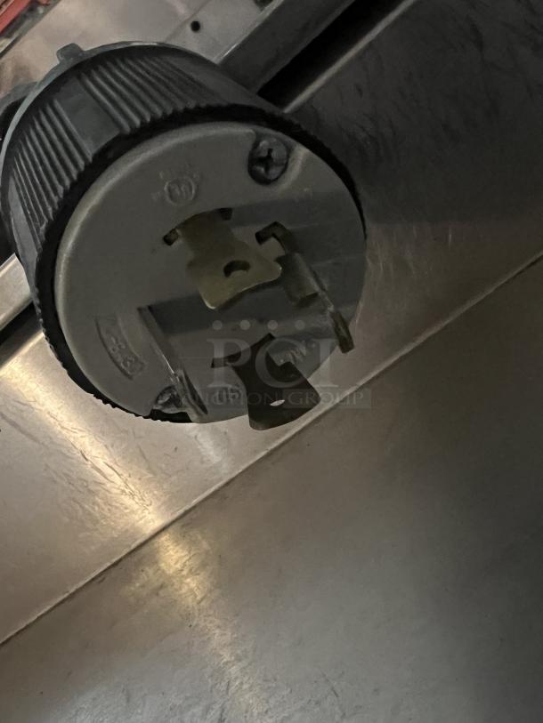 Electrical connector attached to the Fetco Double Coffee/Tea Brewer, Model CBS-2042e, showing a close-up of plug prongs.