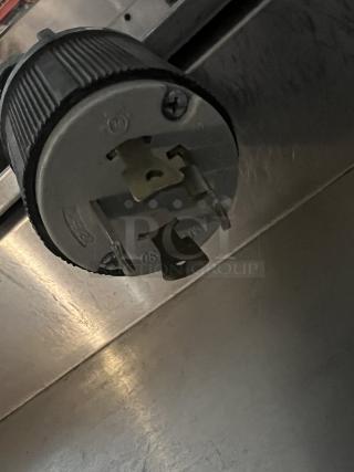 Electrical connector attached to the Fetco Double Coffee/Tea Brewer, Model CBS-2042e, showing a close-up of plug prongs.