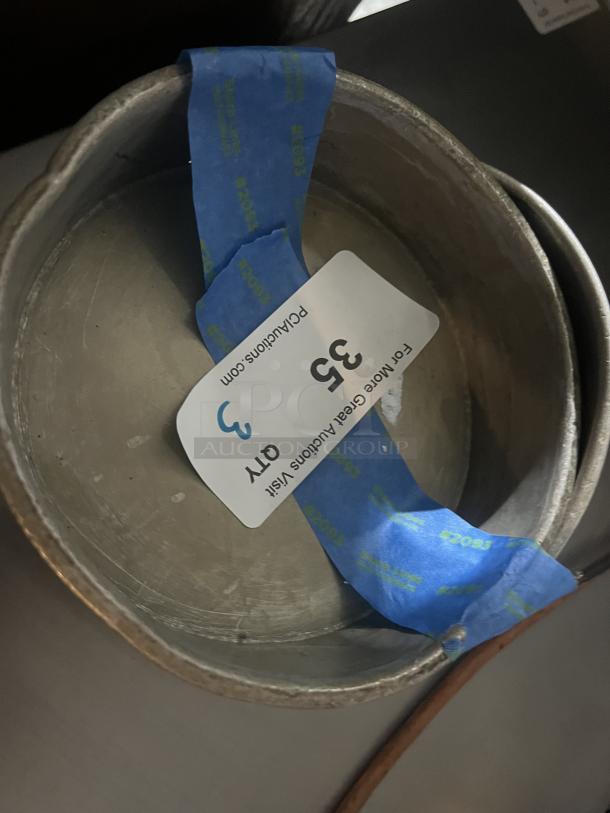 Set of 3 metal cake pans, 7-1/4 inch each, auction tag visible. Fair condition, showing wear. Bid for all three.