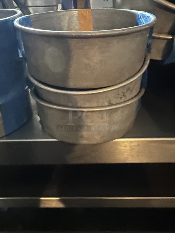 Three stacked aluminum cake pans, 7-1/4 inches in diameter, used condition. Quantity: 3.