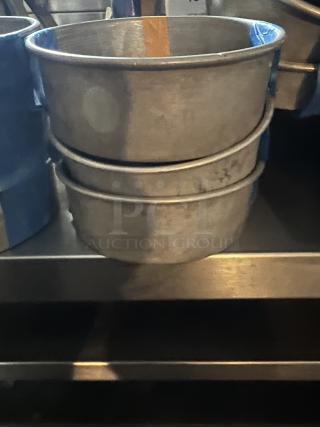 Three stacked aluminum cake pans, 7-1/4 inches in diameter, used condition. Quantity: 3.
