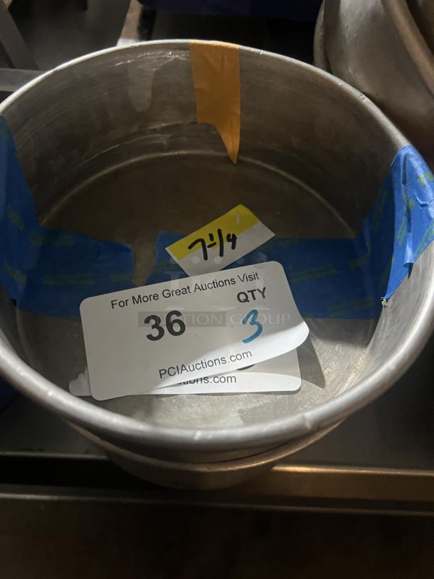 Set of three 7-1/4" metal cake pans. Visible auction tag "36 QTY 3" from PCI Auctions. Good condition.