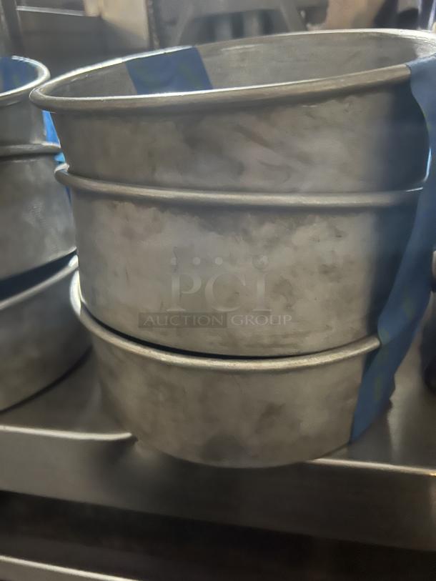 Set of three 7-1/4" metal cake pans, stacked. Used condition with a smooth finish. Auction item bid per pan.
