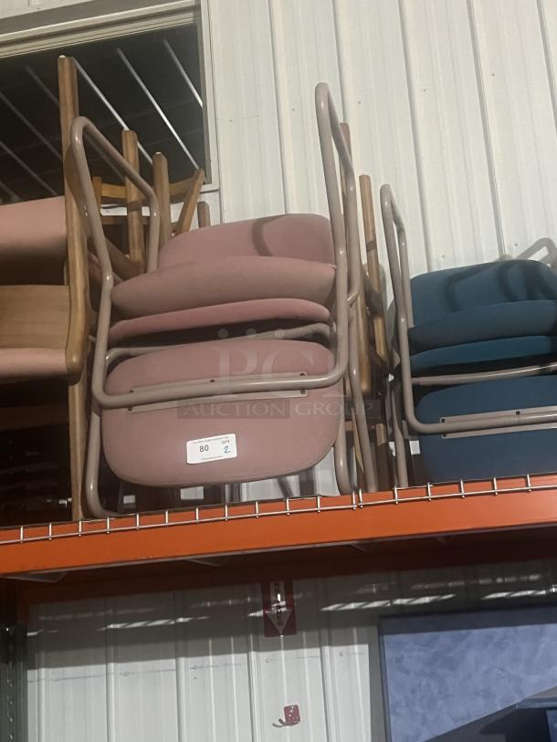 Two office chairs, pink upholstery, metal frames, stacked. Label indicates quantity of 2, item 80. Good used condition.