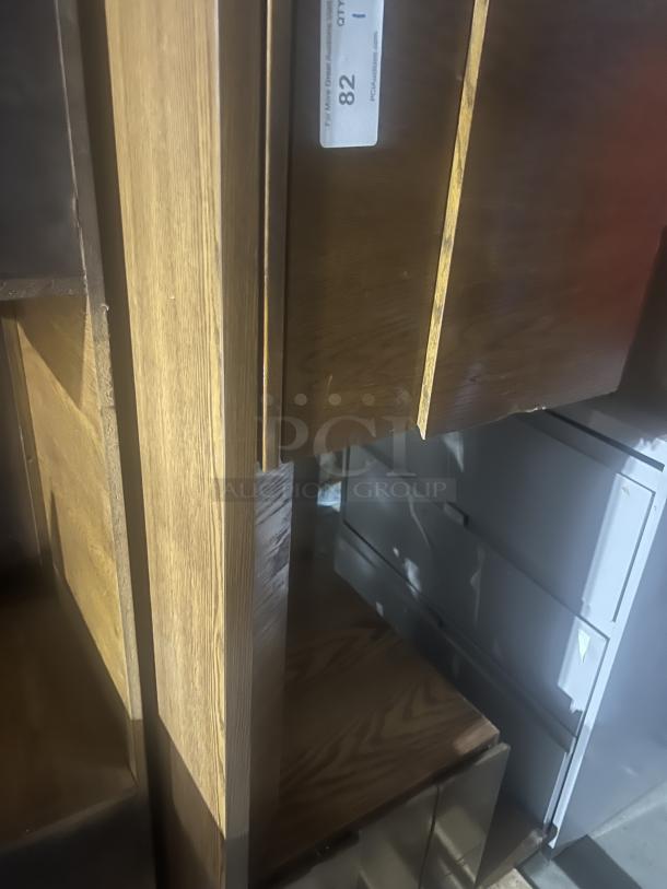 Wood desk with smooth finish, visible grain, and multiple shelves. Auction tag number 82. Good condition.