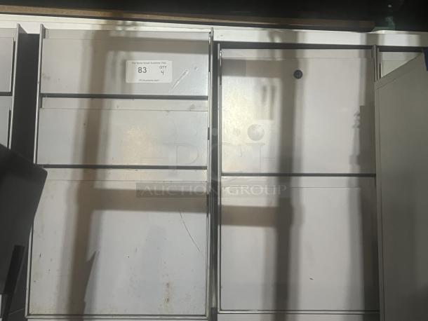Four gray cubicle-style filing cabinets in used condition, auction tag indicating quantity 4.