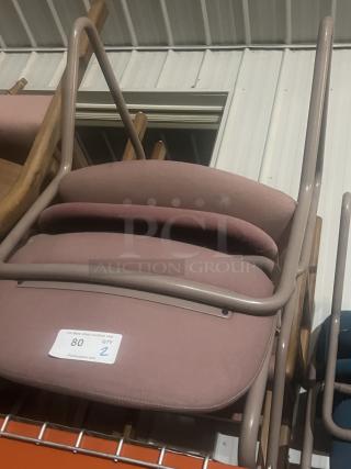 Two pink office style chairs stacked, in good condition. Label indicates quantity as 2, tag number 80.