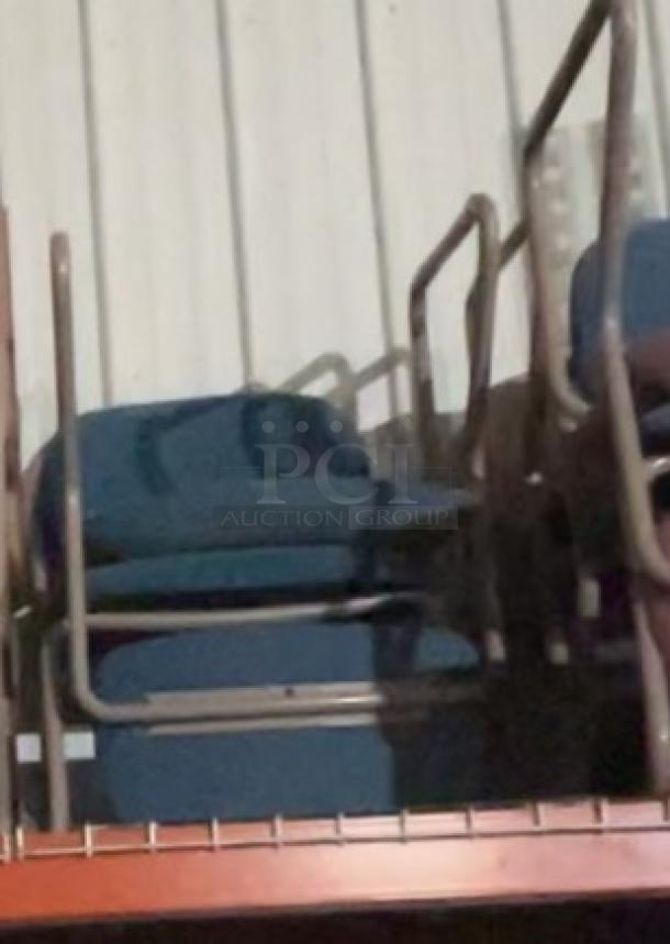 Two blue office-style chairs with metal frames, stacked on a shelf. Good condition. No visible tags or markings.