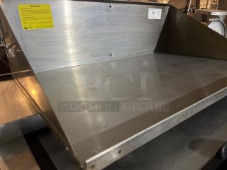 Stainless steel wall mount shelf, 34x21.5x10 inches, minimal wear. Visible yellow warning label, good condition.