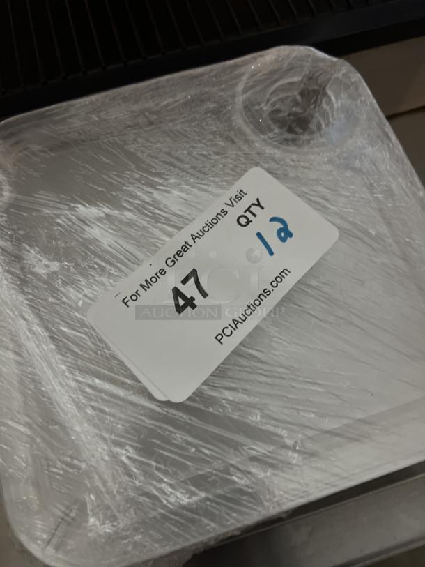 Appetizer trays with wine glass holder, set of 12, wrapped in plastic. Auction label indicates "QTY 12", visit "PCIAuctions.com".