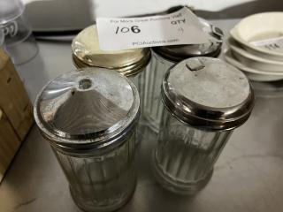 Set of four vintage glass sugar/creamer shakers with metal lids, slightly worn. Auction tag shows item number 106 and quantity 4.
