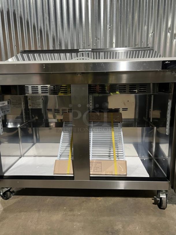 Brand new Blue Air BLPT48HC stainless steel 2-door refrigerated prep table, includes cutting board, food pan, wired rack, on casters.