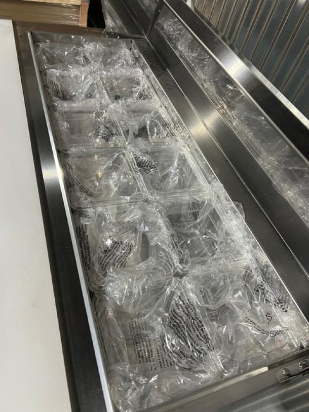 Brand new Blue Air BLPT48HC stainless steel refrigerated prep table with cutting board, clear food pans, and wire rack.