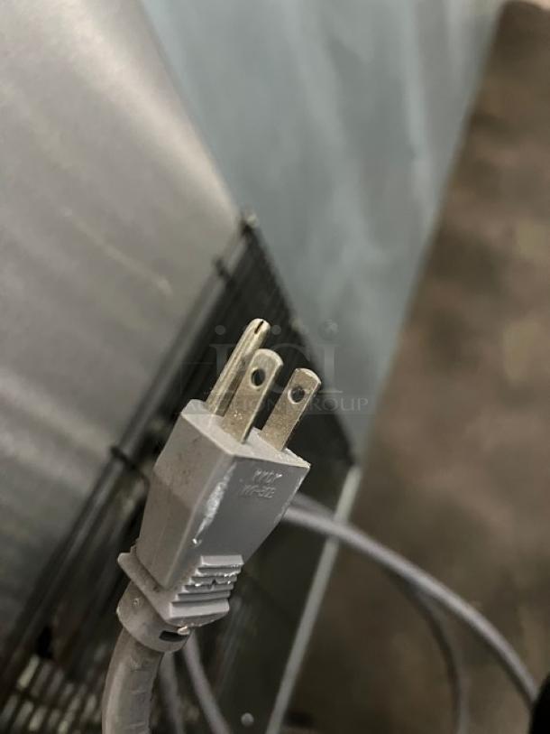 Close-up of a power plug for a Blue Air BAPP67 refrigerated prep table, shown against a wire rack background.