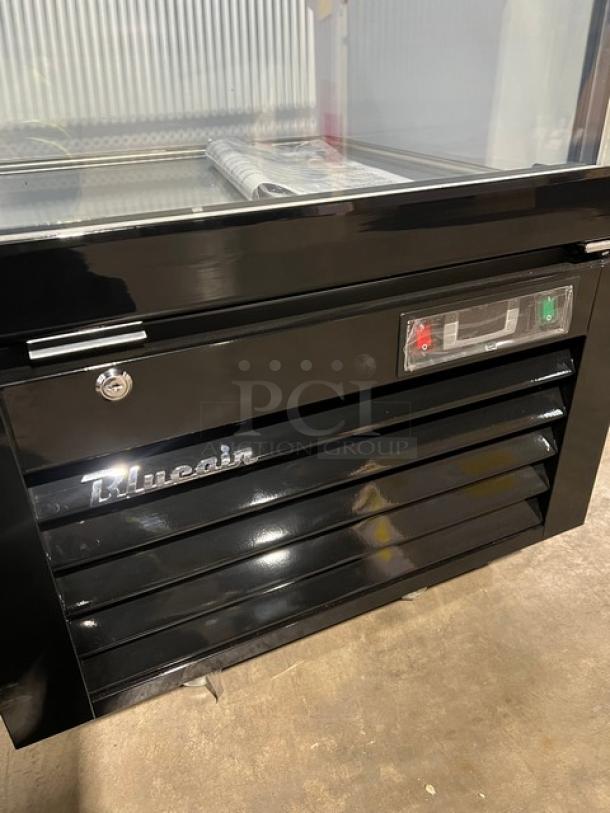 Brand new Blue Air BKGM12-HC merchandiser refrigerator with glass swing door, black/white finish, poly coated rack, on casters.