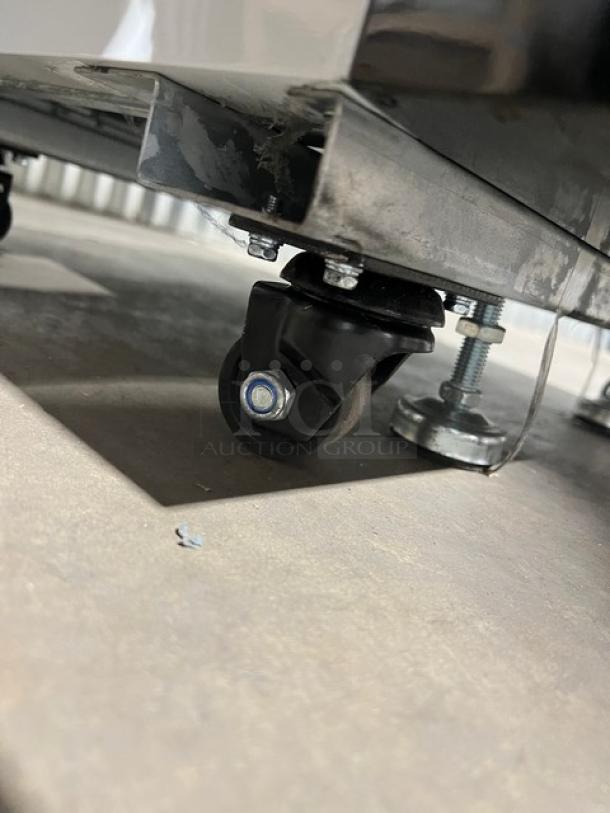 Caster wheel of Blue Air BKGM12HC merchandiser refrigerator, showing sturdy metal construction and smooth rolling capability.