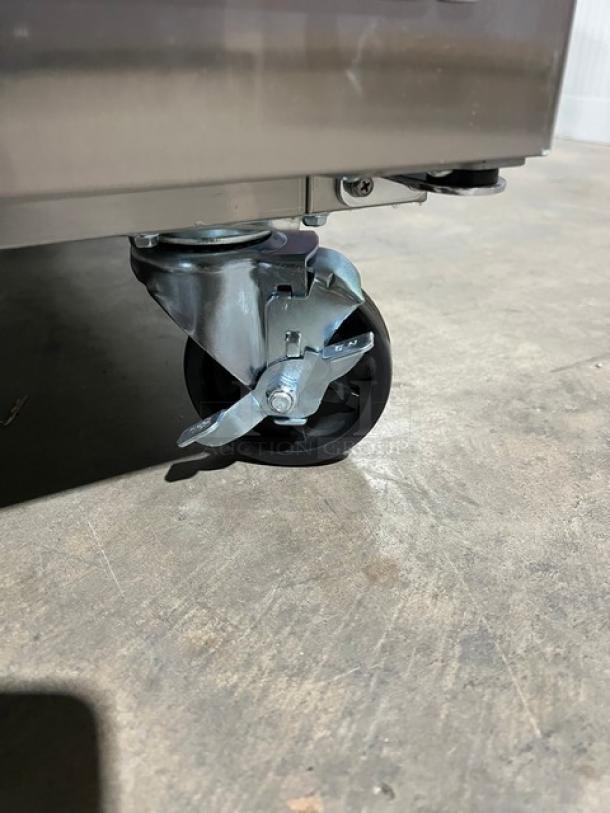 Brand new Blue Air Model BLMT48HC refrigerated prep table caster, showing sturdy construction and mobility features.