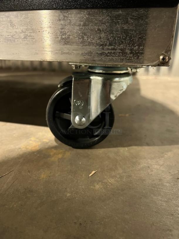 Close-up of a caster wheel on a Blue Air 36" Glass Froster/Bottle Cooler, model BGF-36B, with stainless steel detail.