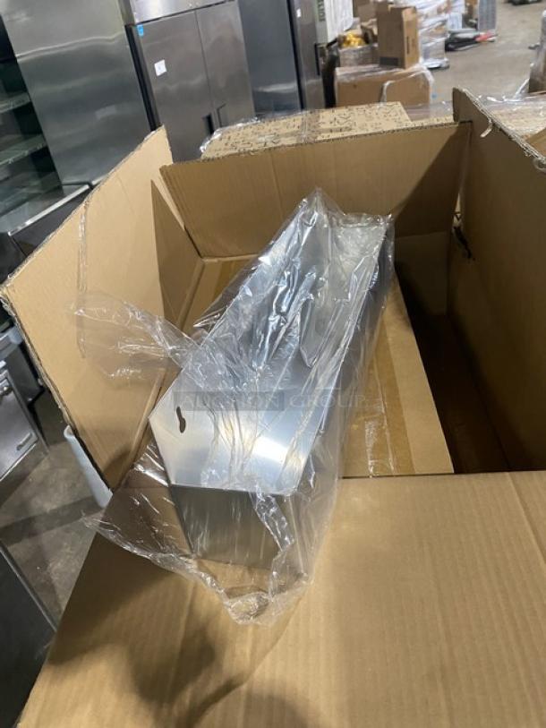 Mixed pallet featuring assorted commercial items, including a stainless steel speed rail wrapped in plastic inside a cardboard box.