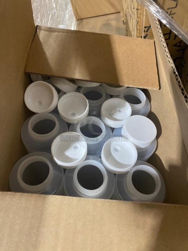 Box of TableCraft commercial clear 12 oz. hinged-top squeeze bottles, model 2112C-1, visible inside for auction.