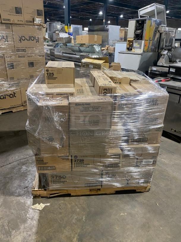 Mixed pallet of new Libbey glassware cases, including customizable pilsner, flute, beverage, highball, iced tea, wine, and goblet glasses, wrapped in plastic.