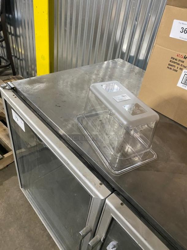 Brand new Winco clear polycarbonate 1/4-size 6" deep food pan with slotted lid, model SP7406/SP7400C, on metal surface.