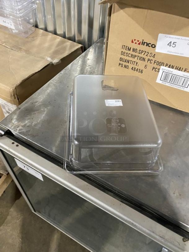 Brand new Winco SP7204 clear polycarbonate 1/2-size 4" deep food pan on metal surface, original packaging.